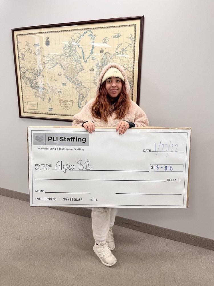 Alyssa holding her PLI Staffing placement check in the Middleburg Heights office, dated 27 January 2022.