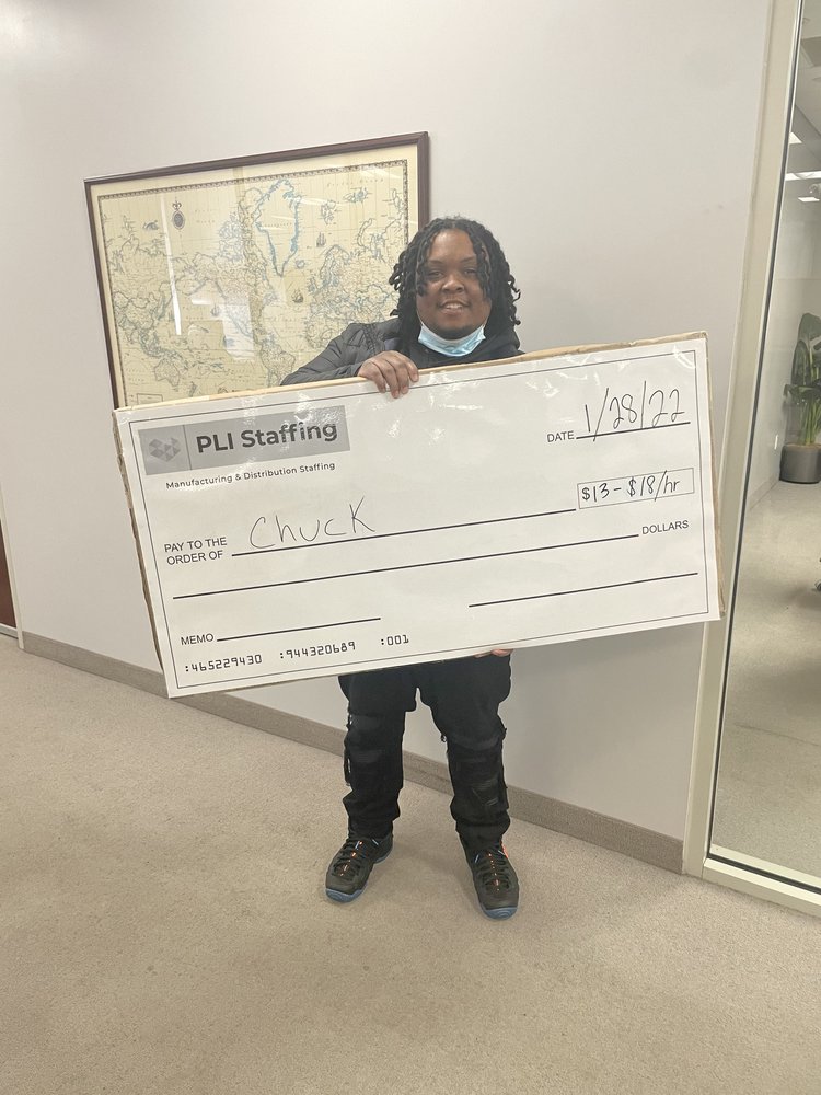 Chuck holding his PLI Staffing placement check in the Middleburg Heights office, dated 28 January 2022.